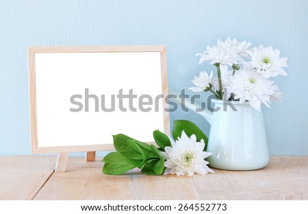 Summer bouquet of flowers on the wooden table and wooden board with room for text with mint background. vintage filtered image 
