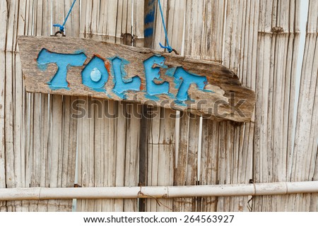 Wood restroom sign on bamboo wood wall