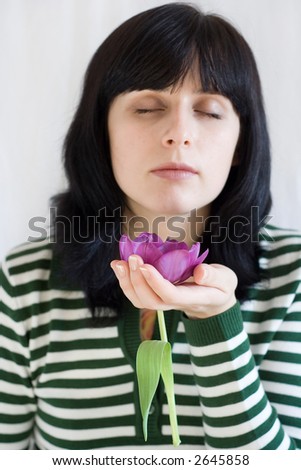 photo of young woman holding purple flower