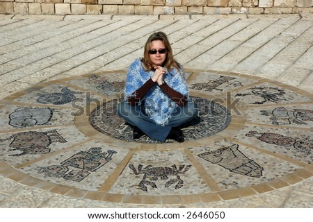 Woman sitting on antic astrological wheel