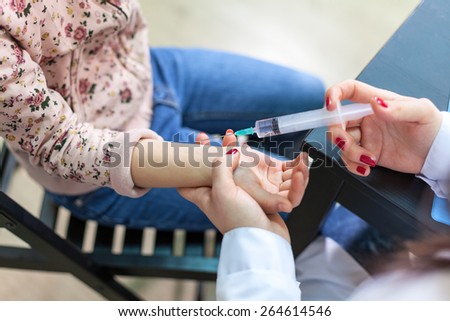 The doctor making vaccination a child's hand, close up view