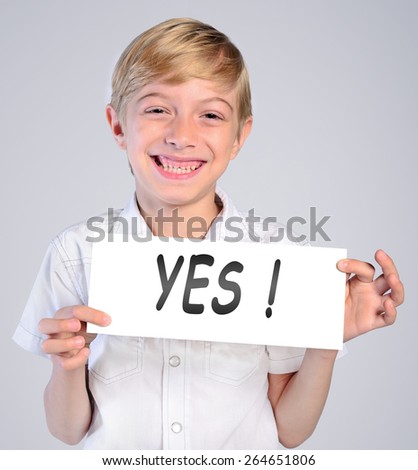 little boy holding paper with yes word