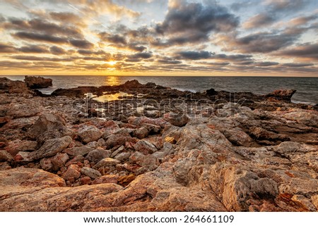 Beautiful dramatic sunrise on the rocky beach