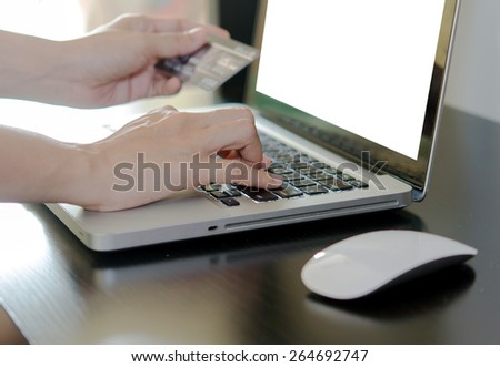 Hands holding a credit card and using laptop computer.shopping online.