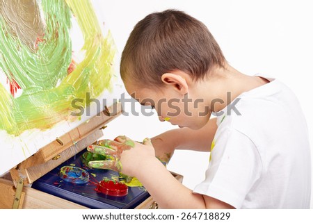 Little boy paints a picture