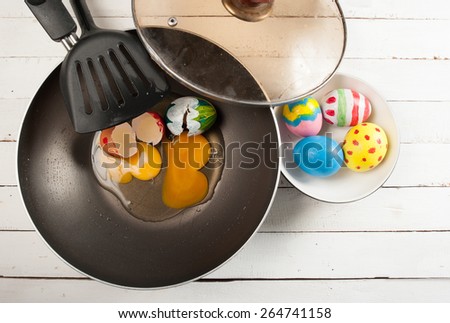 easter eggs and frying pan on wood