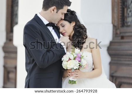 Beautiful, perfect couple posing on their wedding day. Romantic picture with the groom looking at his bride