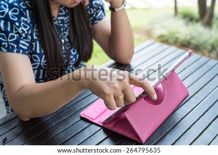 Asian woman see  information in tablet and thinking about it