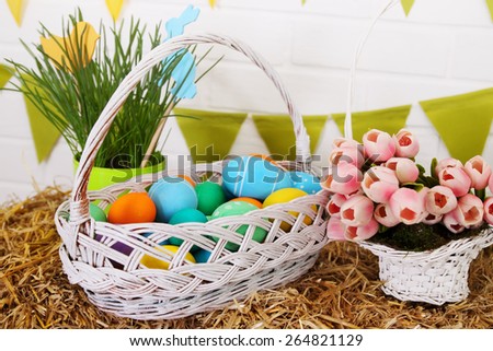 Basket with a colored eggs  basket stands on straw