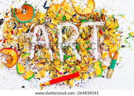 art word on the background of colored pencil shavings on the white