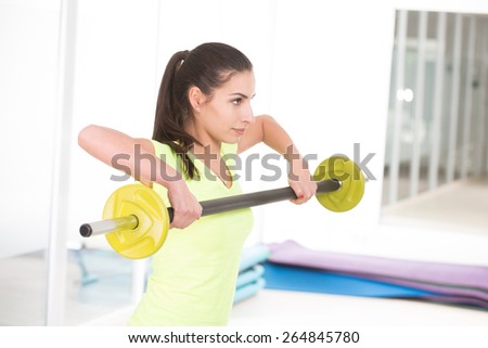 She like to hold barbell. Beautiful sporty woman in gym