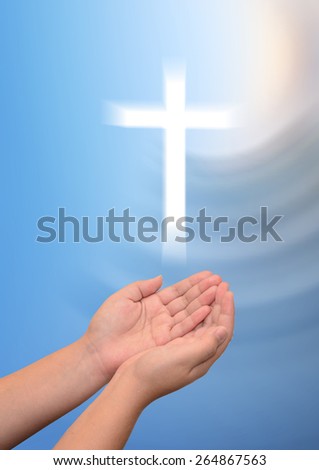 Human open empty hands with palms up, over blurred the cross 