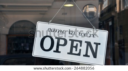 Classic Charm: An Open Sign in Black and White, Hanging on the Exterior Door. The "Open" sign, presented in bold black letters against a crisp white background, stands as a welcoming beacon.