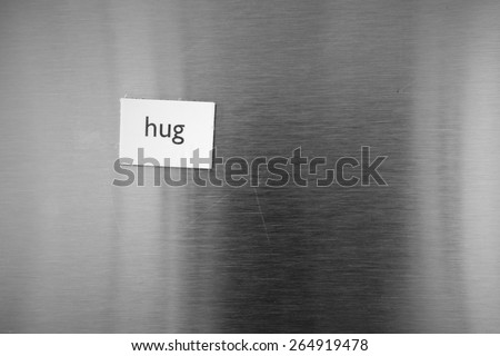 Fridge, refrigerator magnet with the word, text hug stuck on stainless steel.