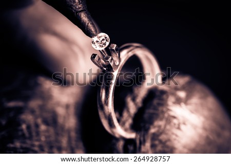 Craft jewelery making.  Measuring of the size of the diamond. Monochrome cream tone. Black and white photography. Royalty-Free Stock Photo #264928757