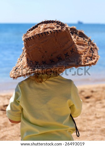 baby in a big cowboy hat on the beach
