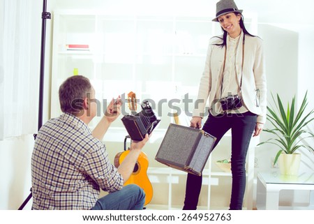 Male photographer photographing woman with retro camera