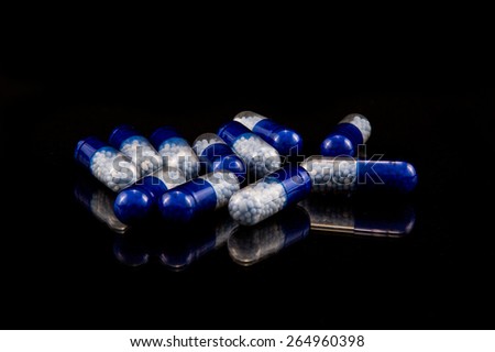 Blue pills on black background isolated