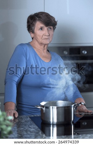 Picture of worried grandma standing in the kitchen