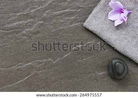 Spa treatment stones and towel border on a tiled floor conveying tranquility