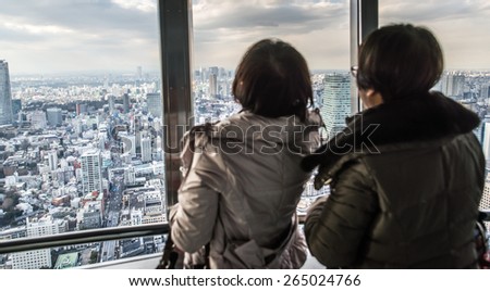 people watching tokyo skyline from view tower. concept about travel, asian metropolis, and people