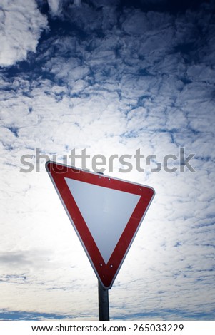 give way road sign, yield sign, with blue sky and clouds