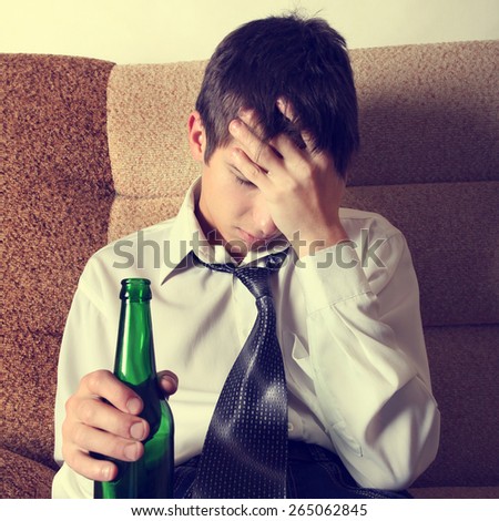 Toned Photo of Sad Teenager with Bottle of the Beer