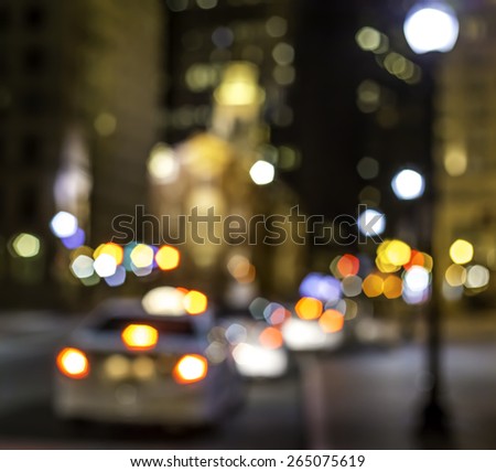 Conceptual photo of Boston in Massachusetts, USA showcasing the shape of the Old Massachusetts State House at night and lots of street lights in an out of focus photo.
