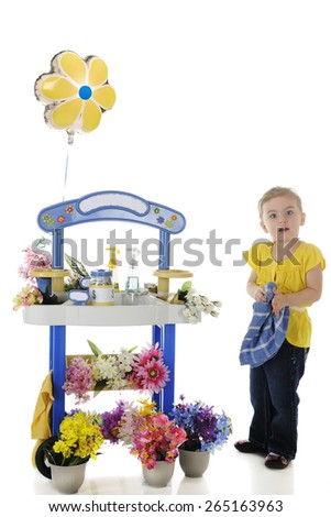 An adorable preschooler looking at viewer as she wipes her hands on a towel as tending her flower stand.  Signs on the stand left blank for your text.  On a white background.