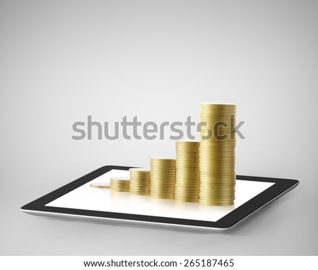 Tablet pc with business graph and golden coin 