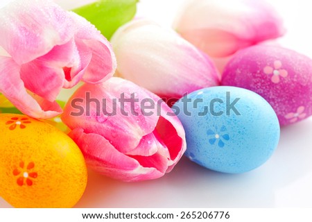 Easter eggs with pink tulip flowers on white background