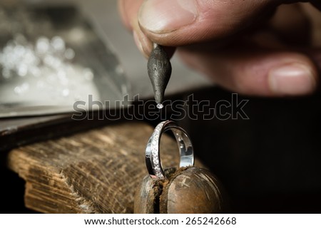 Craft jewelery making. Ring repairing. Putting the diamond on the ring. Macro shot. Royalty-Free Stock Photo #265242668