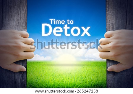 Time to Detox. Hands opening a wooden door then found a texts floating among new world as green grass field, Blue sky and the Sunrise. Royalty-Free Stock Photo #265247258
