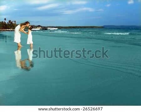 mother and daughter on the beach in the water kiss