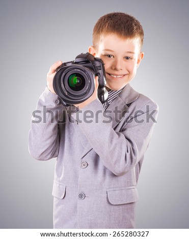 young child holding a dslr camera on a white background