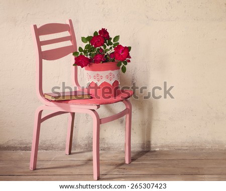 roses on old chair on background grunge wall