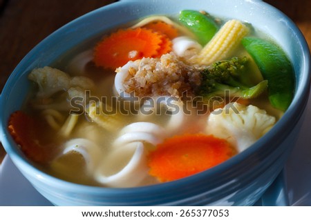 Picture of asian vegetable noodle soup in a white plate