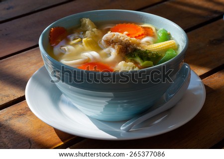 Picture of asian vegetable noodle soup in a white plate