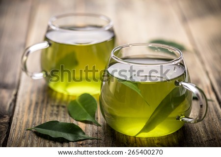 Fresh green tea with tea leaves in the water Royalty-Free Stock Photo #265400270