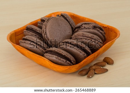 Chocolate macaroons in the bowl on the wood background