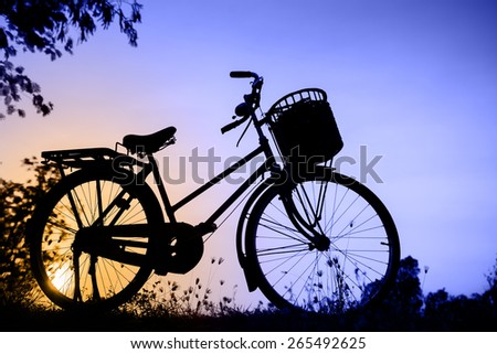 beautiful landscape image with Bicycle silhouette  at sunset