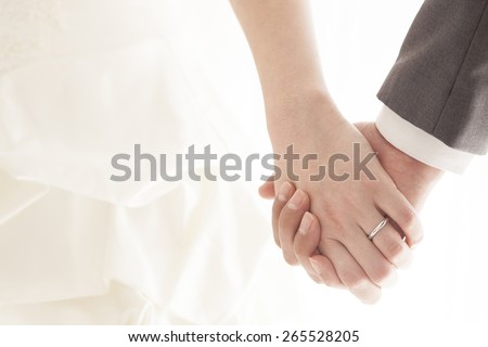 Young married couple holding hands, ceremony wedding day Royalty-Free Stock Photo #265528205