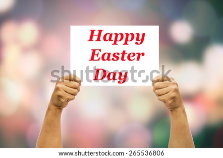 Hand holding white label word Happy Easter Day on blurred background bokeh