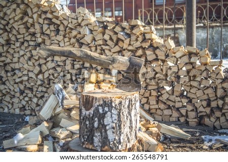 Axe Cut into Wood after Chopping Firewood against stack of wood near rusty metal fence Rural scene 