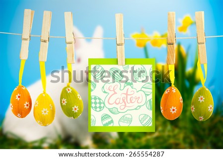 happy easter graphic against white fluffy bunny sitting beside daffodils with easter eggs