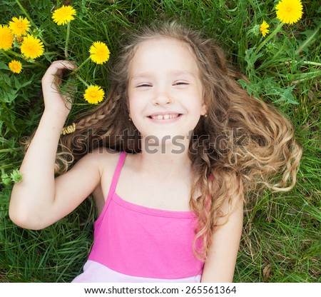 Child at summer. Happy girl outdoors on green grass
