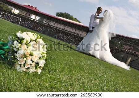 Brides on a football field .  gentle kiss. loving feelings. bridal bouquet.