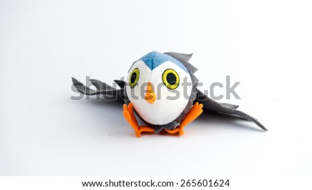 Cute and colourful mini owl bird plush doll on empty background. plush Slightly defocused and close-up shot. Copy space.