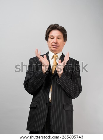 Businessman holding something in his hands on a gray background