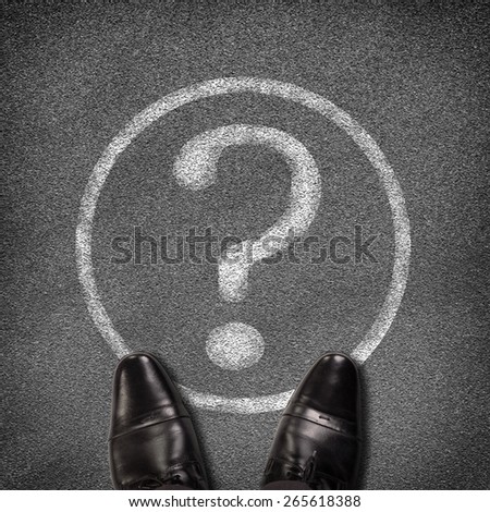 Top view of shoes standing on asphalt road with circle and question mark. Business concept